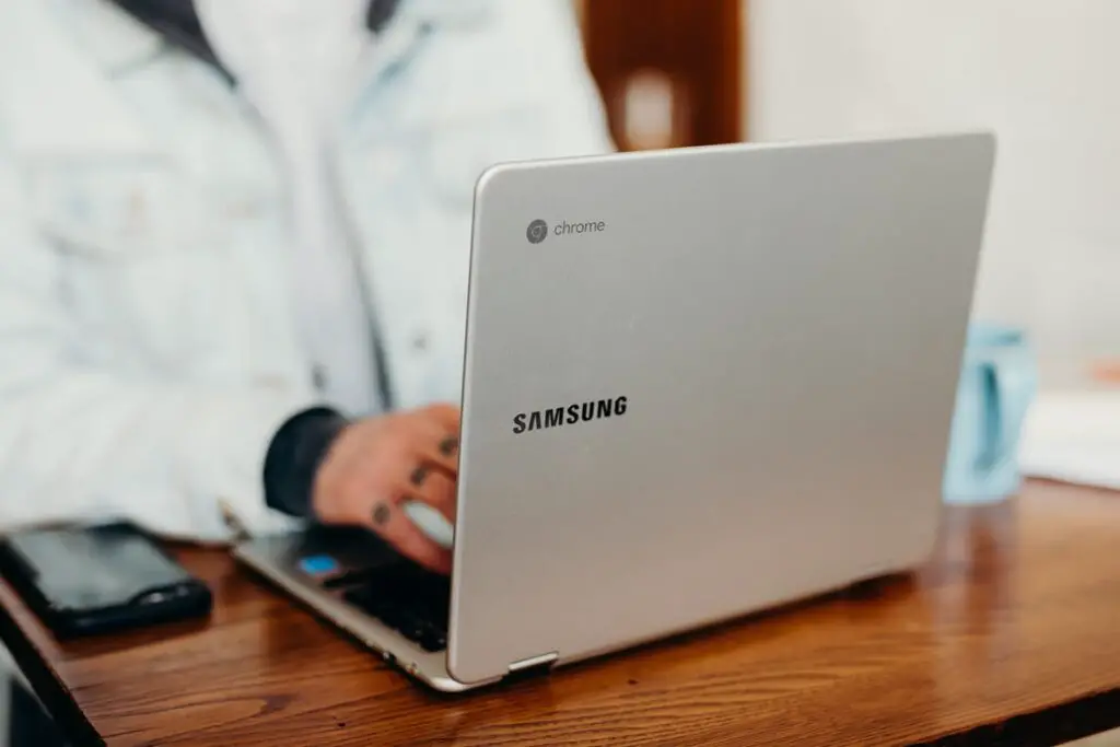 A person sat at a table using a Samsung Chromebook. 