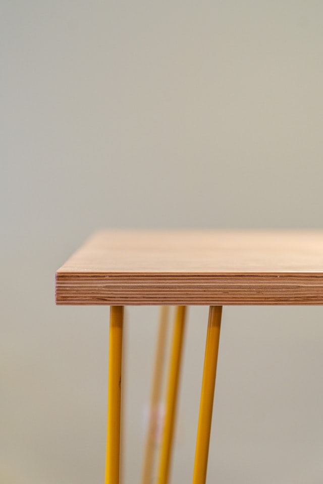 Wooden table with yellow metal legs.